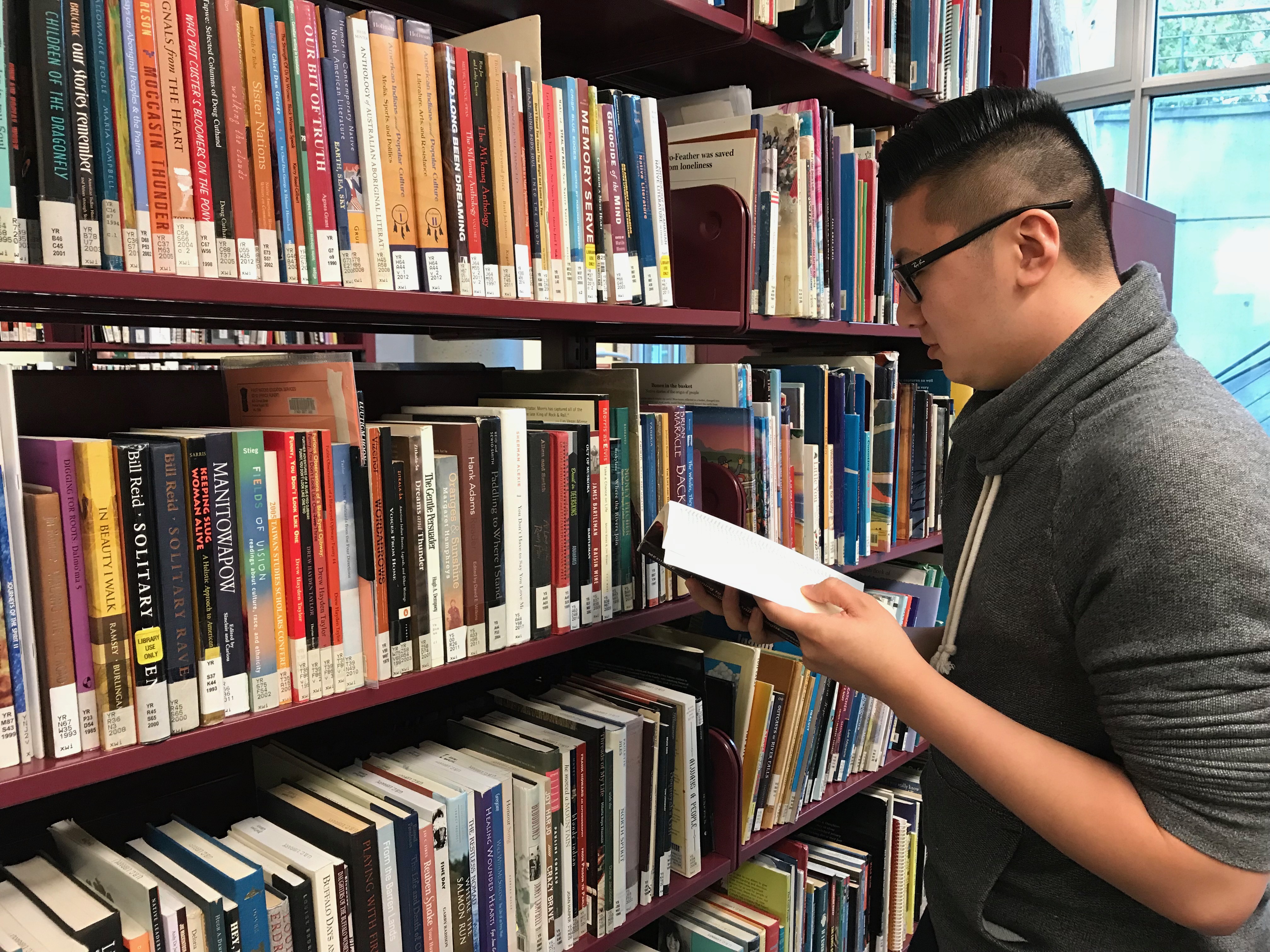 man with book in library